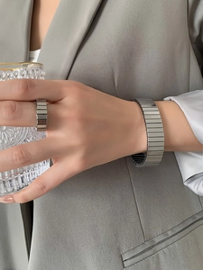 Close-up of industrial style silver cuban link bracelet and ring set on model wrist