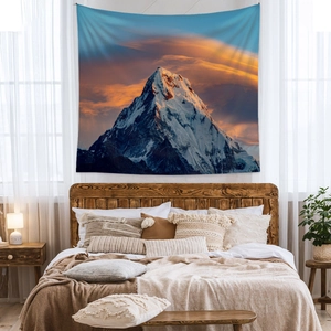 Bohemian wall tapestry featuring a sunset snow mountain landscape in cozy bedroom setting