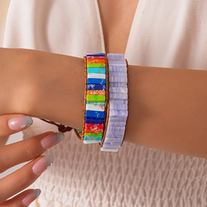 Detail view of woven leather and natural stone beaded bohemian wrap bracelets on wrist
