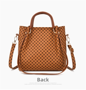 Rear view detail of brown printed handbag featuring geometric patterns and golden hardware