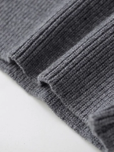 Detailed close-up of dark grey thick ribbed knit fabric showing high-quality texture