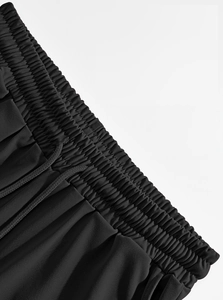 Detail of men's black linen trousers showing elastic waistband and drawstring design