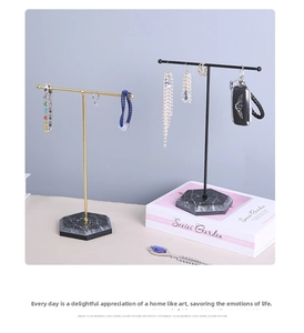 Detail of T-bar jewelry stands with gold and black metal rods and marble hexagon bases