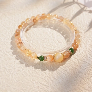 Gros plan détaillé du bracelet en perles de citrine jaune avec accents verts et anneaux dorés
