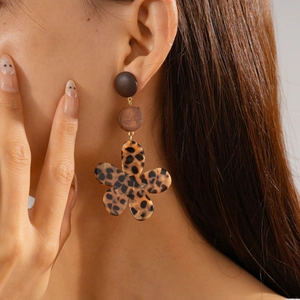 Détail de boucles d'oreilles vintage en résine marron et fleurs à motif léopard
