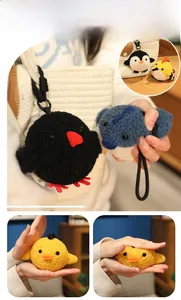Détail macro du porte-clés oiseau en peluche montrant sa texture douce et l'effet de pression