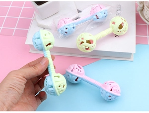 Detail of macaron-colored baby rattle toy with ergonomic handle and internal bells
