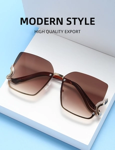 Fashionable oversized sunglasses with brown gradient lenses and gold metal temples on a stand