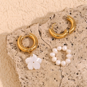 Asymmetric 18K gold plated stainless steel floral earrings with pearls on stone background