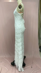Detailed side view of white floral lace evening gown with slim fit mermaid cut on mannequin