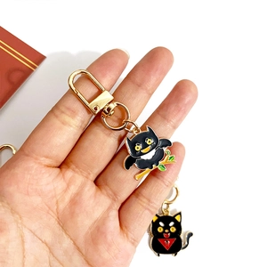 Handheld dark owl cartoon keychain made of black enamel and gold-tone metal hardware