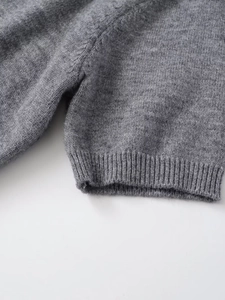 Détail du revers côtelé et texture en maille douce sur pull gris à manches courtes