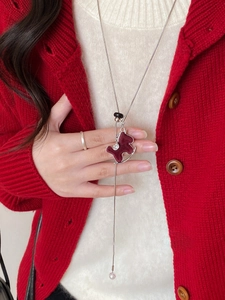 Macro detail of wine red velvet pony pendant on elegant silver snake chain necklace