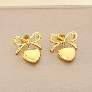 Détail des boucles d'oreilles en acier doré avec nœuds et pendentifs en cœur