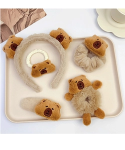 Detailed set of brown plush capybara hair accessories including headband and scrunchies