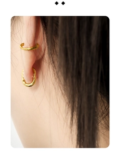 Detailed close-up of golden geometric S925 silver hoop earrings with lava texture