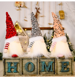Three glowing Christmas gnomes with sequined hats on a rustic wooden HOME box