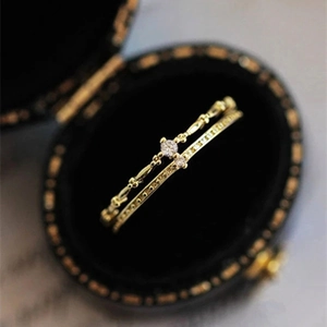 Détail d'un ensemble de bagues dorées vintage avec double rangée de zircons brillants