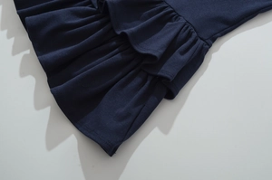 Détail rapproché du tissu en maille bleu marine avec volants et finitions de couture