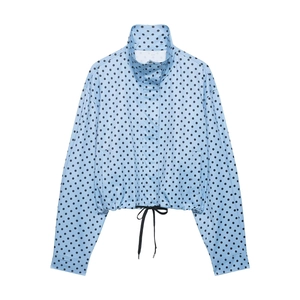 Detail of light blue polka dot jacket featuring a high collar and adjustable drawstring hem