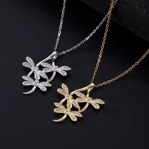 Detail of gold and silver dragonfly pendant necklaces with sparkling zircon inlay