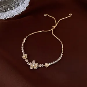 Elegant gold flower bracelet with sparkling zircons on a luxury brown velvet background