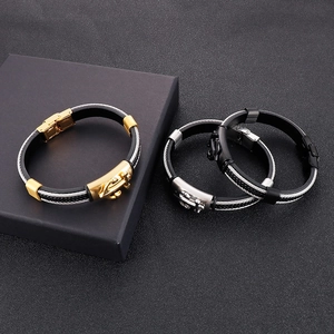Vista dettagliata di bracciali con ancora in finiture oro, argento e nero su sfondo scuro