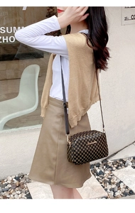 Detail of crossbody bag featuring gold geometric print and metallic logo on brown leather