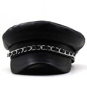 Detail of black faux leather baker boy hat featuring silver chain strap and pebbled texture