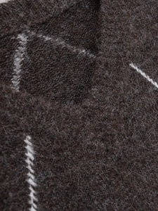 Close-up of dark brown knit sweater with fuzzy mohair texture and white stitching details
