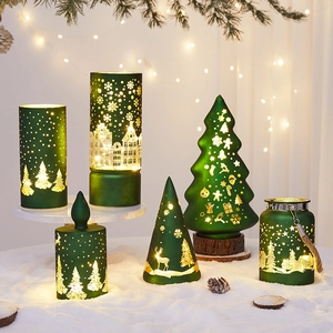 Green glass Christmas LED lanterns with gold patterns on a snowy festive background