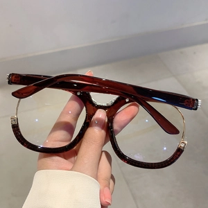 Detail of tortoise frame glasses with gold metal trim and sparkling rhinestone accents