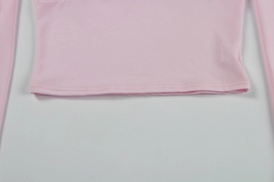 Detail shot of the pink long-sleeve top showing high-quality double-needle hem stitching