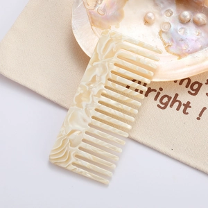 Elegant wide-tooth acetate comb in cream marble finish with vintage minimalist design