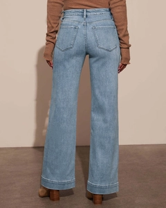 Detail view of high waist light blue denim wide leg trousers with back pocket stitching