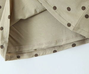 Gros plan du tissu kaki à pois montrant les détails de couture et la texture