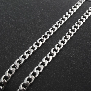 Polished silver stainless steel Cuban link chain necklace on a textured black background