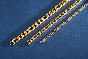 Three sizes of golden Figaro chains in stainless steel displayed on a blue background