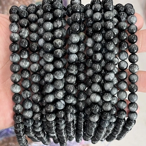 Detailed view of hand-held natural eagle eye stone beads with unique cat-eye effect