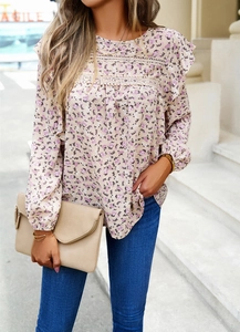 Close-up of floral print blouse with lace patchwork and ruffled sleeves on model