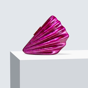 Close-up of shell-shaped acrylic evening clutch with purple marble texture on a white stand