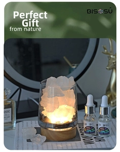 Close-up of crystal stone aromatherapy set with wooden LED base and essential oil bottles