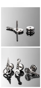 Macro shot of stainless steel stud earrings set featuring scissor and wrench tool shapes