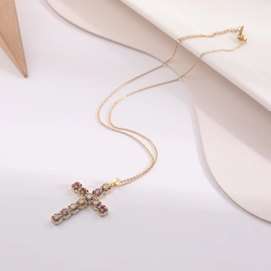 Detailed view of golden cross pendant featuring vibrant colorful zircon gemstones