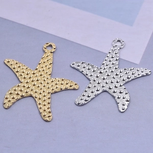 Detailed view of starfish pendants in gold and silver finish with textured surface