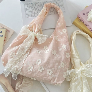 Detail of floral lace embroidery and large ribbon bow on a stylish tote bag