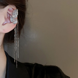 Detail showing a silver butterfly ear cuff with sparkling zircon and long metal tassels