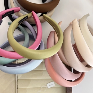 Close-up of assorted colorful satin headbands showing smooth fabric texture and colors