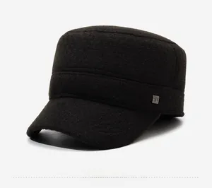 Detail of the warm wool texture and silver SD metal logo on the brown winter flat cap