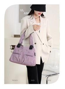 Lifestyle shot of high-capacity lavender tote bag with front zipper and black straps